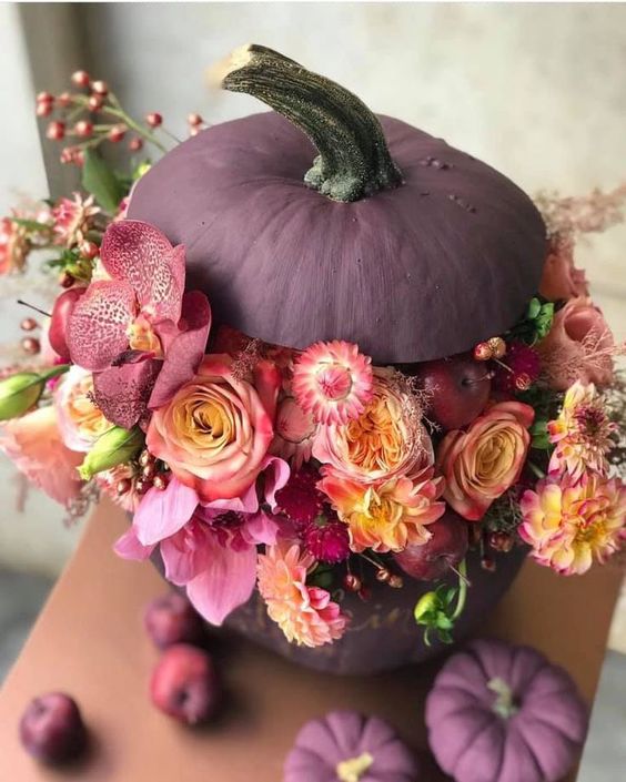 a matte purple pumpkin with pink, mauve, yellow blooms, berries and some greenery is amazing for Halloween