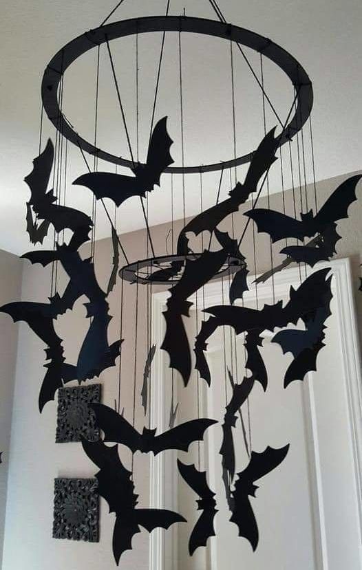 a black chandelier with black paper bats hanging down is a lovely mobile idea for any Halloween space