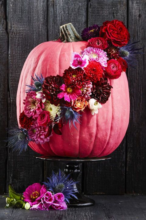 a pink pumpkin decorated with fresh thistles, burgundy, punk, red and hot pink blooms attached inspires and wows