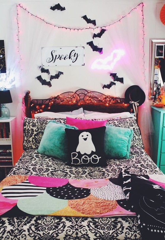 a bright Halloween bedroom done in pink, green, black and white, with bats, neon lights and lots of prints is super fun