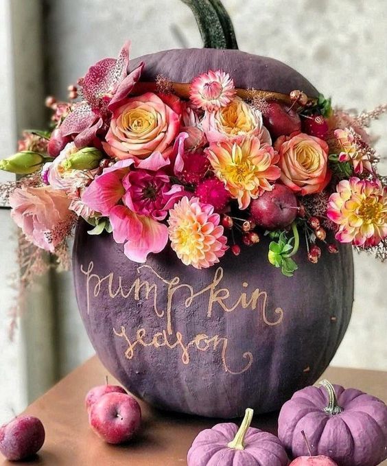 a sophisticated matte purple pumpkin done with pink, neutral, yellow blooms, berries and apples and gold calligraphy