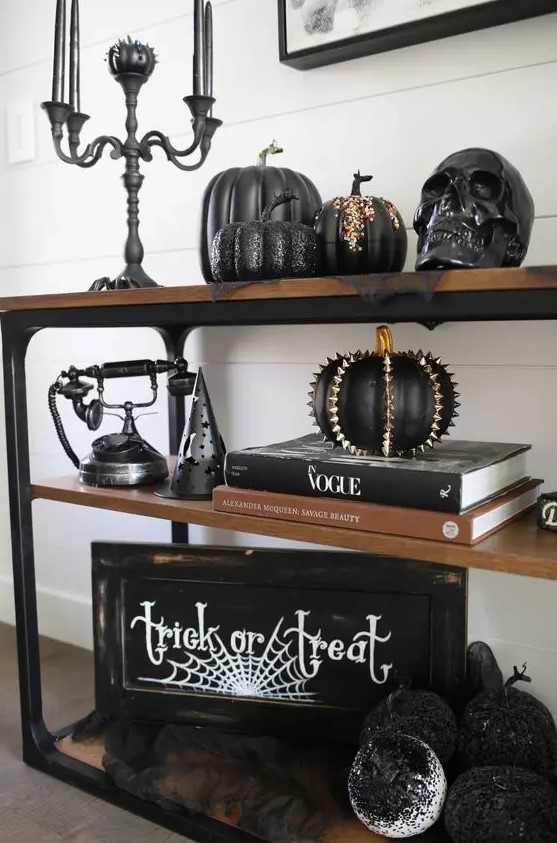 gorgeous Halloween console decor with a sign, some cool black pumpkins with spikes and rhinestones, a black candelabra with black candles