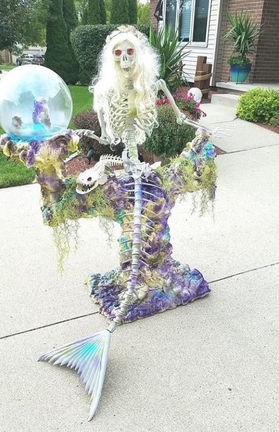 a super eye-catchy mermaid skeleton with seashells and moss is a cool idea for Halloween decor but in an unusual way