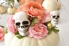 43 pretty Halloween decor of a white pumpkin, pink faux blooms and skulls is a lovely idea for a pastel Halloween party