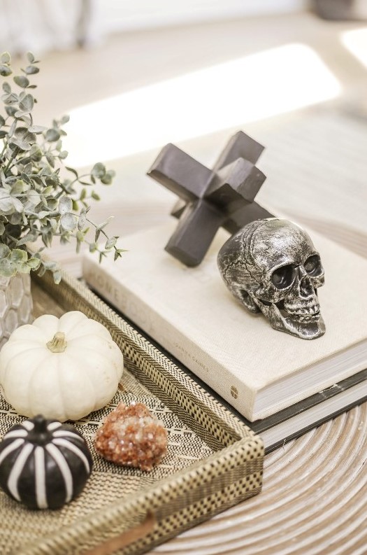 style your coffee table with a skull and a couple of pretty black and white pumpkins for modern Halloween decor