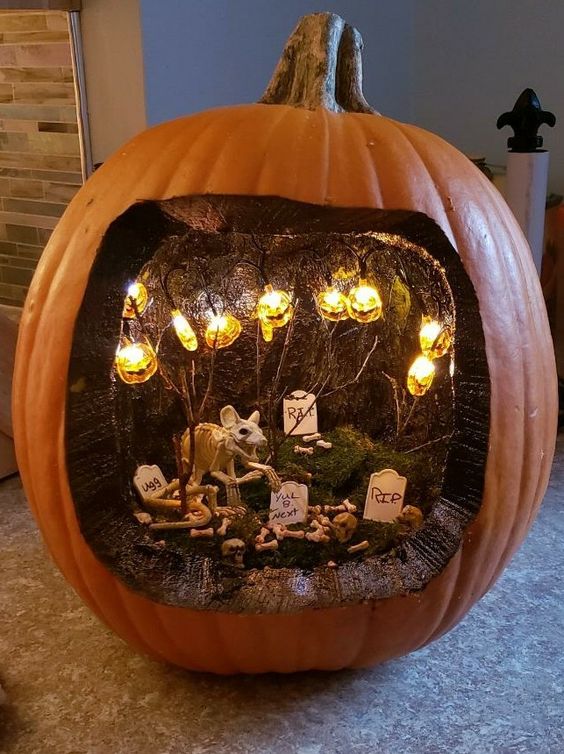 a Halloween diorama with jack-o-lantern lights, a rat, a graveyard and moss is a lovely idea for the holiday