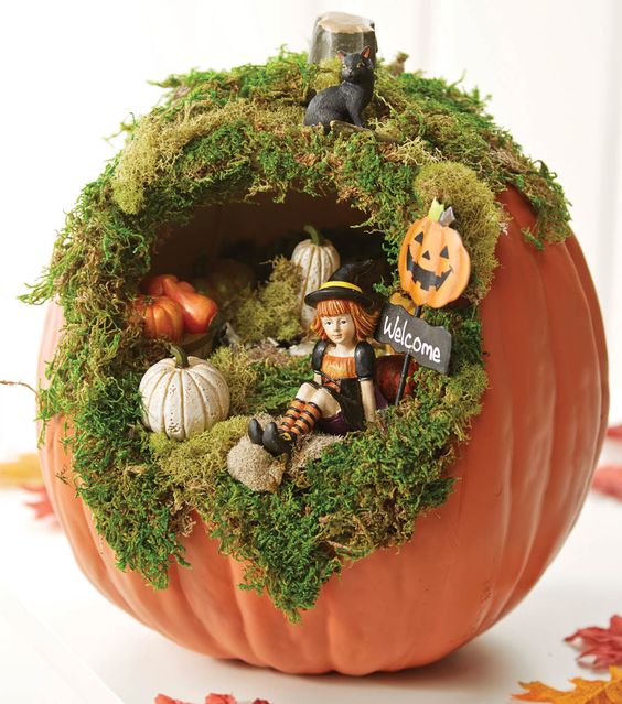 a cute Halloween diorama with moss, small pumpkins, a little witch and a black cat on top is a very fun solution for a kids' party