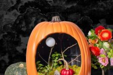 a simple and bright Halloween pumpkin with moss, tombstones, greenery and branches plus a red pumpkin inside it is fun