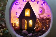 a white pumpkin diorama with purple bat lights, a black house with a ghost and a moon, with small pumpkins and hay