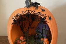 an orange pumpkin with a haunted house, hay and a scary tree plus a number of jack-o-lanterns is a great idea for Halloween