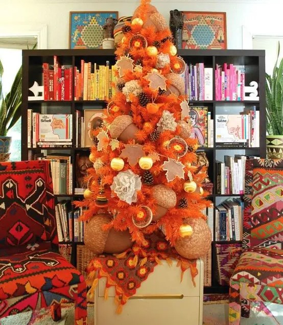 a beautiful fall tree in orange, with pinecones, citrus, oversized acorns and ornaments is very unusual