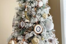 03 a flocked Christmas tree with white glitter ornaments, gold ones, agate slices and gold antlers plus lights is very free-spirited