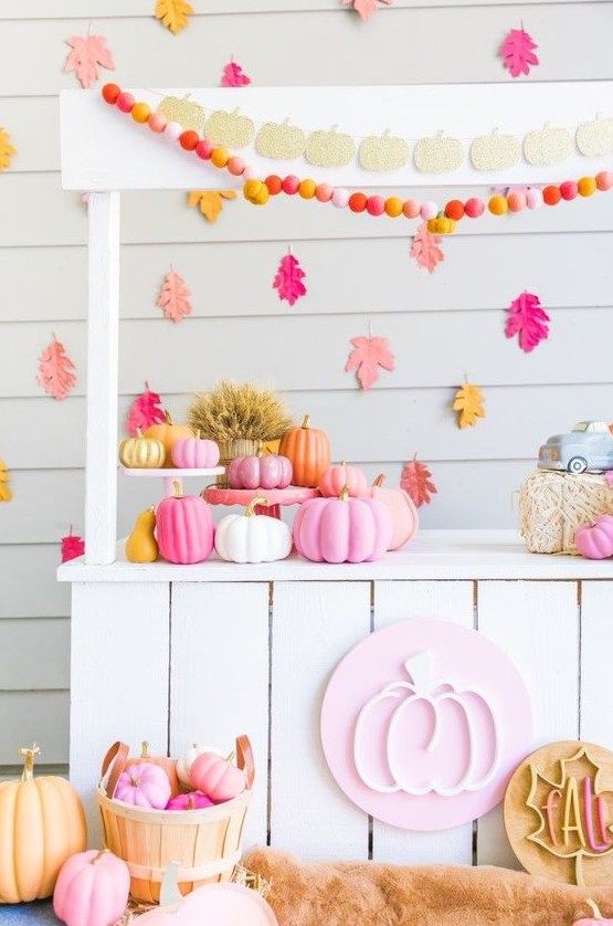 a bright Thanksgiving pumpkin stand with colorful garlands and banners, bright pumpkins in baskets and bright leaves