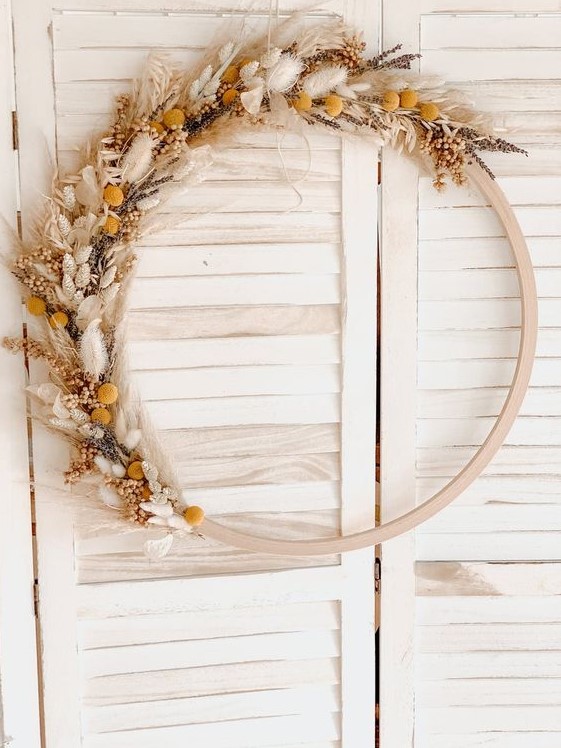 a boho Thanksgiving wreath of a wooden hoop, various dried grasses and blooms is a chic solution