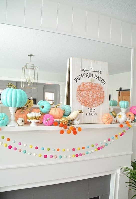 a colorful fall or Thanksgiving mantel with bright pompoms, bold pumpkins, a plaque sign and white birds