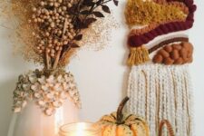 08 a bright fall woven hanging, a pumpkin and a candle, a vase with dried branches and berries for boho Thanksgiving decor