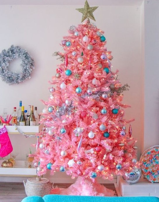 a candy pink Christmas tree with neutral, metallic and blue ornaments and lights looks very sweet and very cute