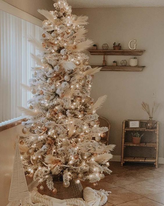 an amazing neutral boho Christmas tree decorated with pampas grass, gold and metallic ornaments, white ones and lights