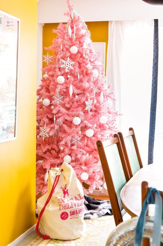 a delicate pink Christmas tree decorated with white ornaments of various looks is a tasteful and very girlish choice