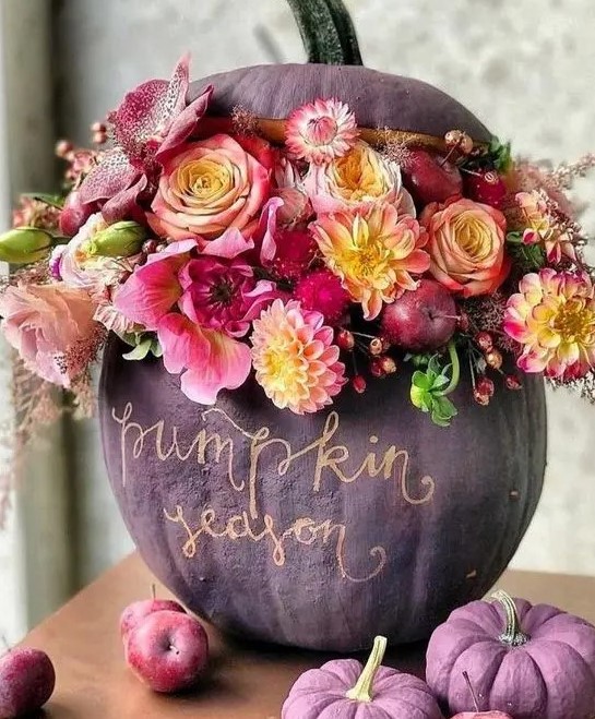 a sophisticated matte purple pumpkin done with pink, neutral, yellow blooms, berries and apples and gold calligraphy