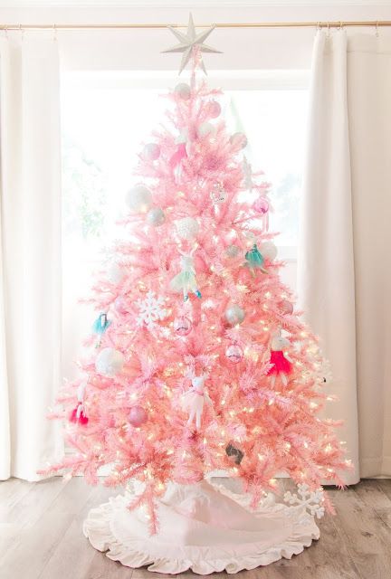 a light pink Christmas tree with lights and vintage ornaments and toys is a lovely idea for a kids' room