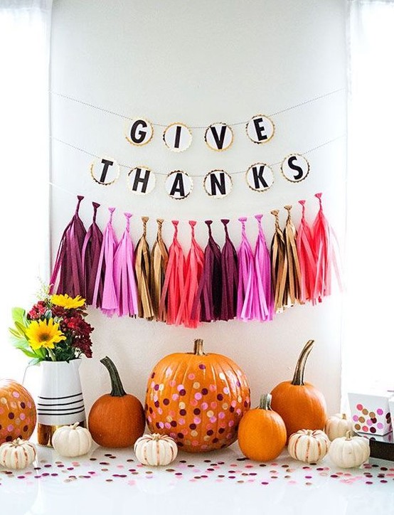 a pumpkin stand with colorful tassels and a banner, bright polka dot pumpkins and bold blooms is pure fun