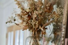 13 boho Thanksgiving decor with dried blooms, leaves and grasses, some natural pumpkins and pink candles