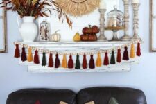 15 bright boho Thanksgiving decor with a bright tassel and wooden bead garland, wooden candleholders, a wheat wreath and some bold branches