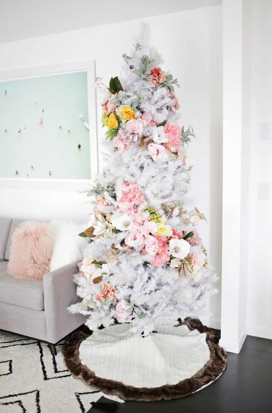 a delicate white Christmas tree with pink, white and yellow florals covering it in a swirl, with pale greenery is an out of the box idea