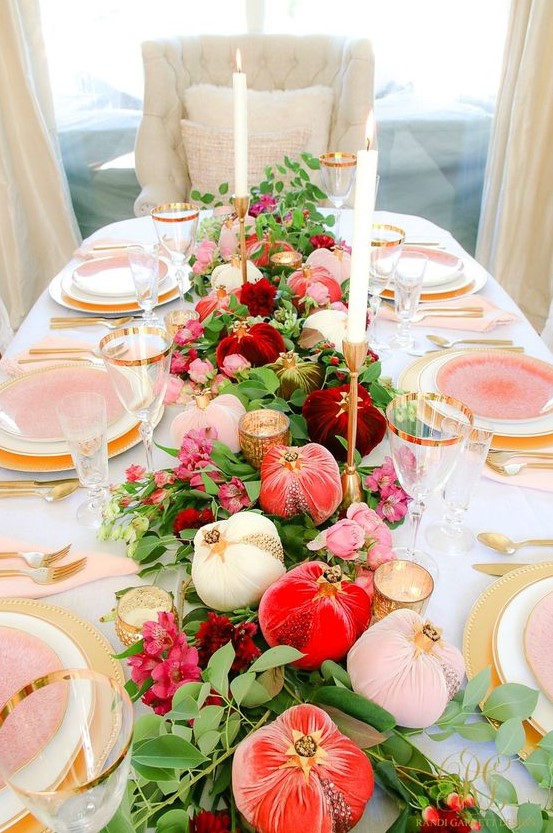 a bright and elegant Thanksgiving tablescape with white, blush, coral and burgundy velvet pumpkins, gold chargers and pink plates