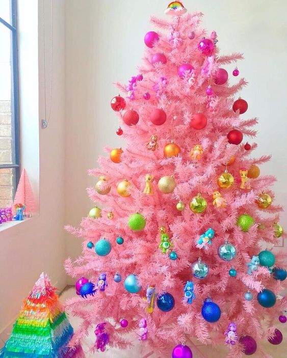 a pink christmas tree styled like a rainbow is a fun and cool idea for a bright holiday space