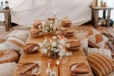 22 a boho thanksgiving feast space with terracotta linens, white blooms and rust candles plus lots of pillows