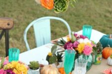 23 a bright Friendsgiving tablescape with colroful blooms, pumpkins, succulents and cacti, a cage with blooms and a pumpkin