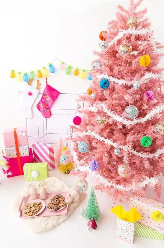a pastel pink Christmas tree with colorful paper and glass Christmas ornaments and white garlands is a colorful modern solution