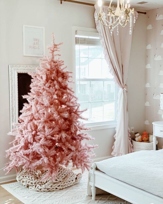 a pink Christmas tree with no decor at all but a chunky knit cover for the base is an awesome idea for modern spaces