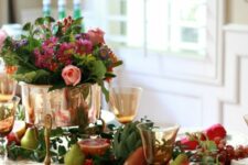 24 a bright Thanksgiving table setting with bold blooms, fruit, veggies and greenery, red napkins and gilded cutlery