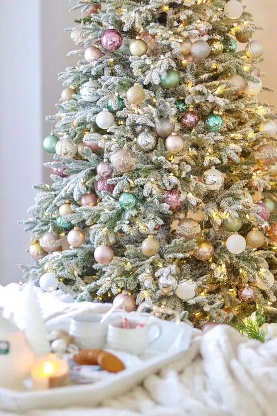a Christmas tree decorated with blush, pastel pink, green, gold glitter ornaments and lights is a beautiful solution with a soft feel