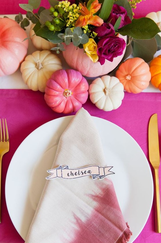 a bright Thanksgiving tablescape with a hot pink tablecloth, bold pumpkins and bold blooms, dip dyed napkins