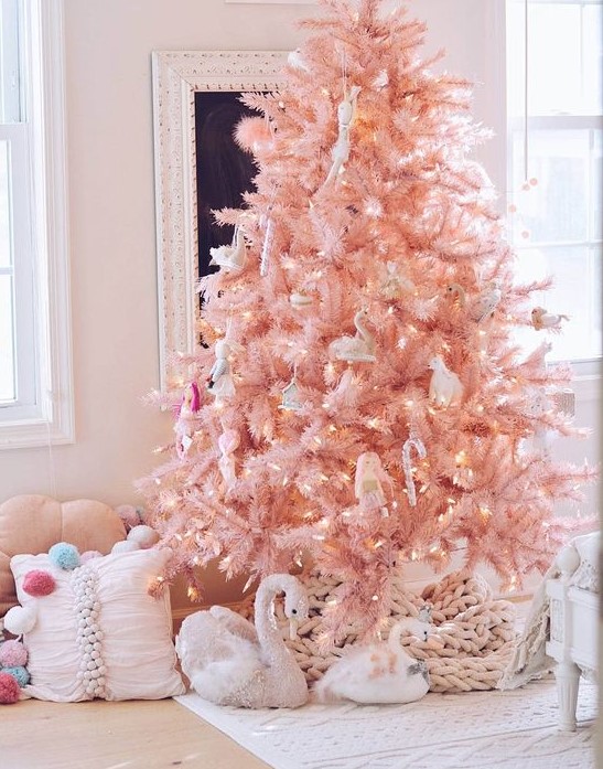 an adorable blush pink Christmas tree with lights, animals and birds plus a blush chunky knit blanket at the base