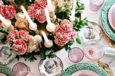 28 a colorful Thanksgiving table setting with pink and green plates, pink blooms and greenery, lots of candles and pink glasses