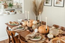 28 a cozy boho Thanksgiving table with neutral pumpkins, white candles, woven placemats, neutral napkins and gold cutlery
