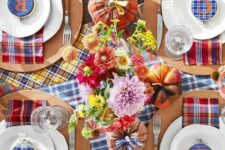 29 a colorful Thanksgiving tablescape with bright plaid table runners and napkins, plaid embroidery hoops, bright flowers and plaid pumpkins