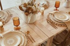 29 a cozy boho Thanksgiving tablescape with woven placemats, printed plates, warm-colored napkins and lovely dried flower centerpieces