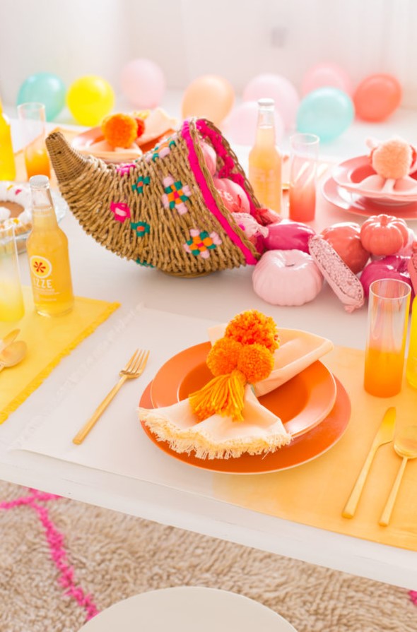 a colorful Thanksgiving tablescape with ombre placemats, a cornucopia with pink and emerald touches and colorful pumpkins