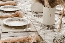 32 a neutral boho Thanksgiving tablescape with wheat and grass centerpieces, striped placemats, blush napkins and printed plates
