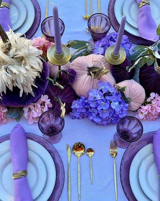 a glam Thanksgiving tablescape with a lilac tablecloth and napkins, lilac candles, purple, deep purple and violet blooms and gilded cutlery