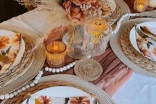 33 a pretty boho Thanksgiving table setting with a rust runner, a large rust rose and dried frond centerpiece, wooden beads, woven placemats