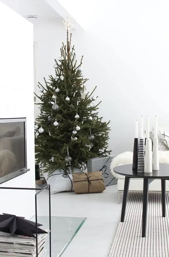 a modern Scandi Christmas tree with white, clear and metallic ornaments and no lights for a laconic look