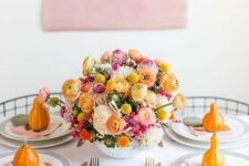 34 a modern and bright Thanksgiving tablescape with bold blooms in the center and orange pumpkins is amazing