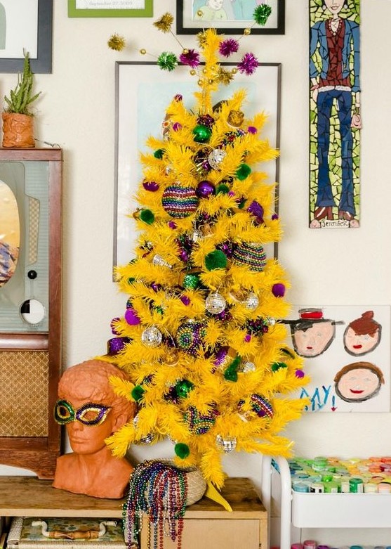 a small yellow Christmas tree with green and purple ornaments is a fresh and crazy color combo that you may rock to stand out